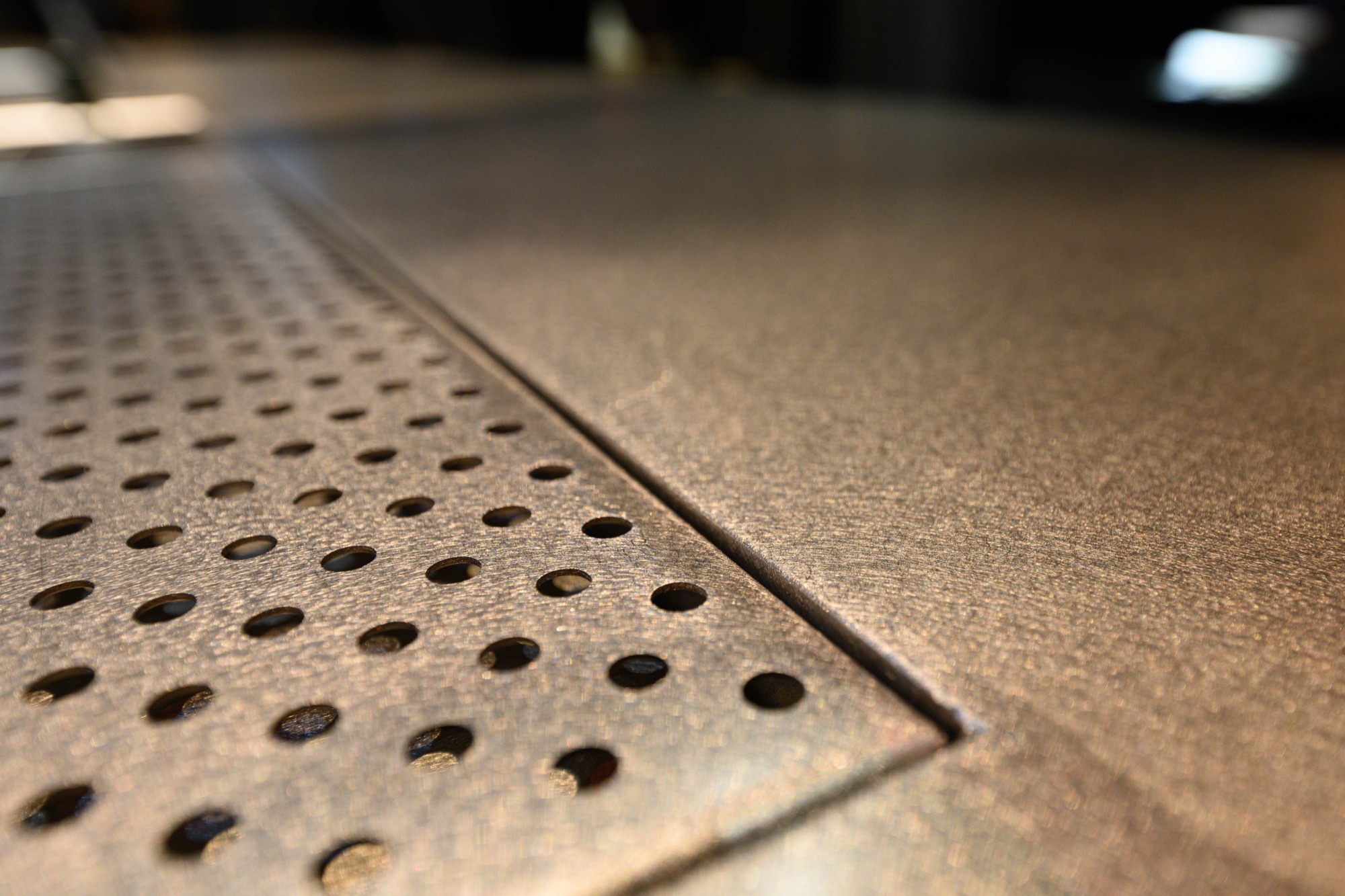 Close crop of the Myata bar counter edge, hand-distance view of the vibration finish texture on 304 stainless steel